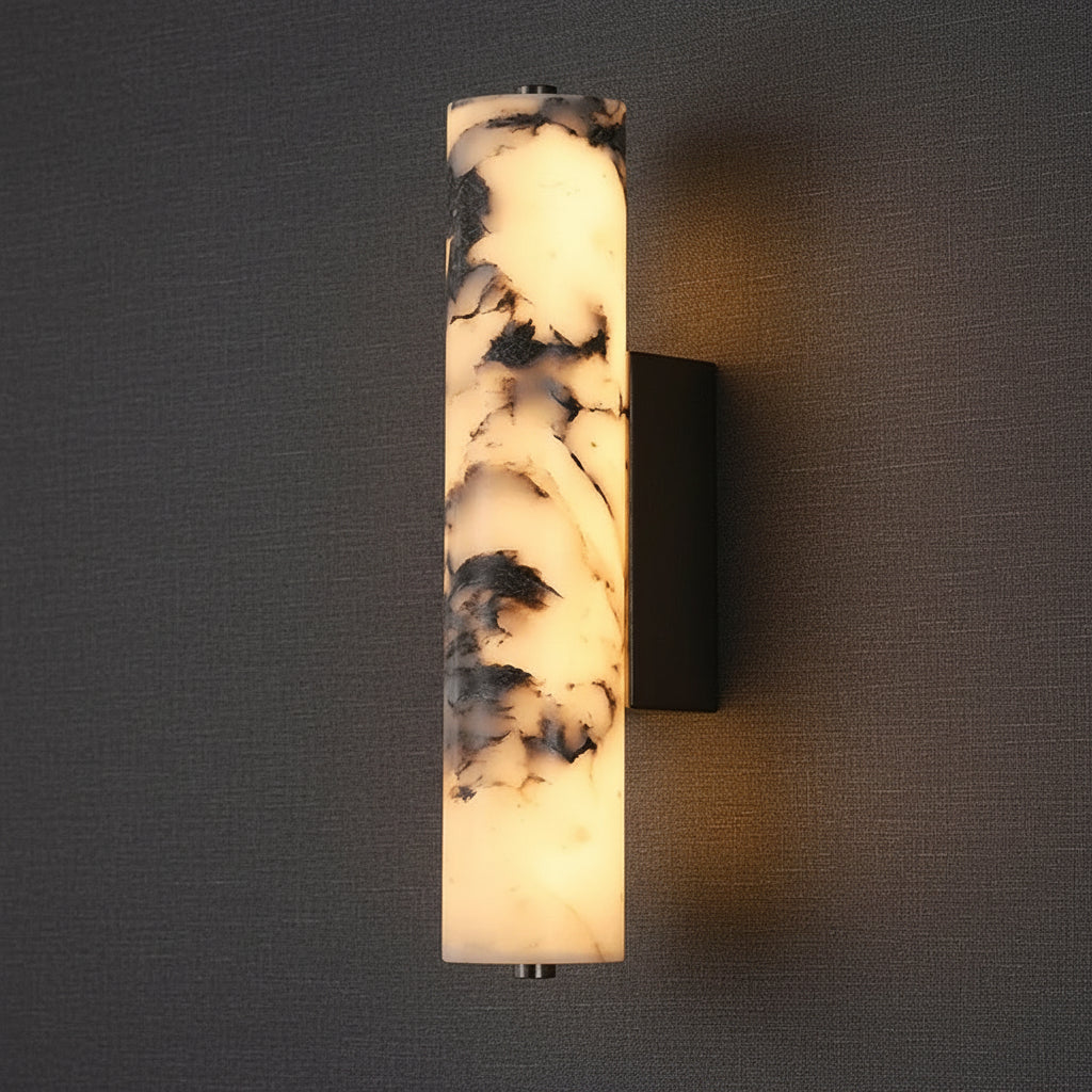 Marble cylindrical wall sconce with black bracket and warm illuminated diffuser