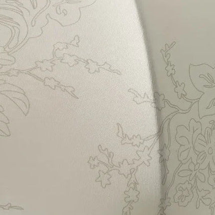 Close-up of cream fabric pendant shade with subtle embossed botanical pattern
