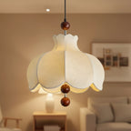 Cream scalloped pendant light with warm glow and brown wooden ball pull-down accents