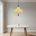 Cream scalloped pendant light with brown wooden balls hanging over a round table