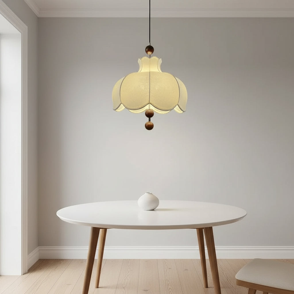 Cream scalloped pendant light with brown wooden balls hanging over a round table