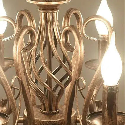 Antique gold cage chandelier close-up with curved lattice and candle holder tops