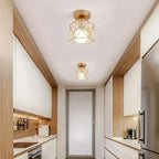 Geometric cage flush-mount ceiling light in gold with exposed bulb on ceiling