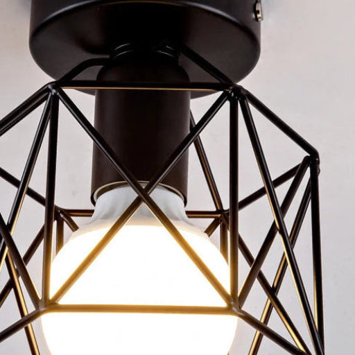 Close-up geometric cage ceiling light with black metal frame and lit glass bulb