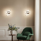 Pair of spiral ribbon LED wall lights with polished metal strips and angled wall brackets
