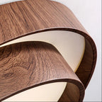 Close-up of dual-ring ceiling light: woodgrain brown rings with white inner diffuser