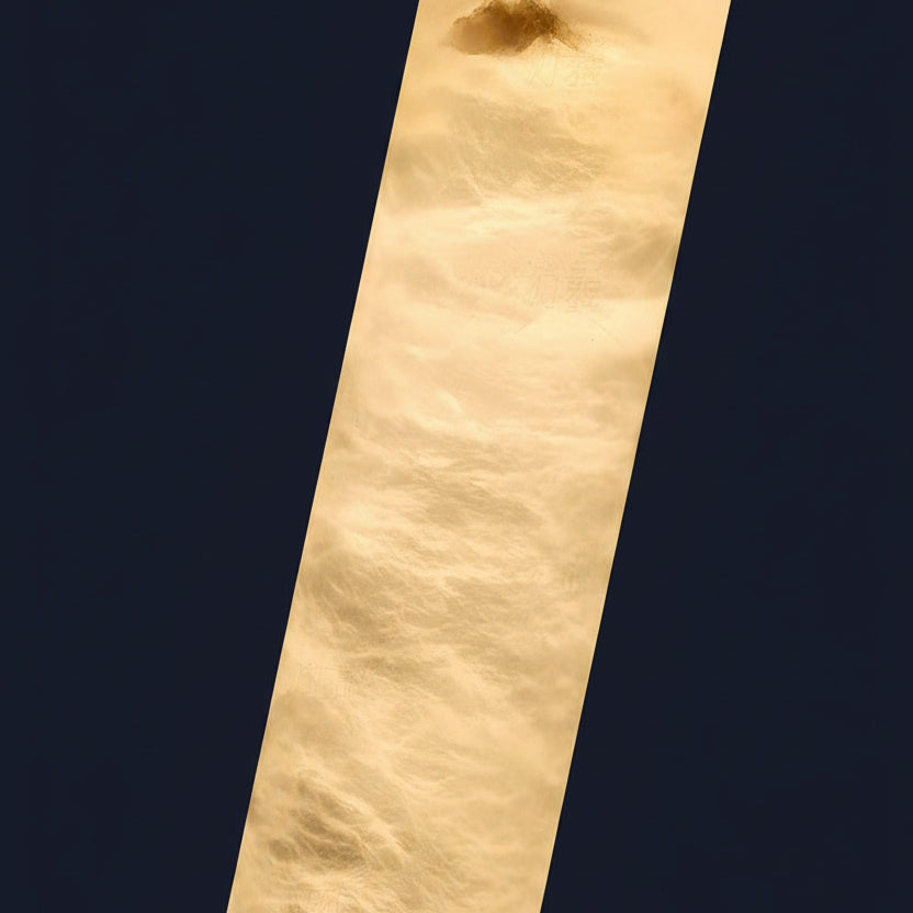 Close-up of cream alabaster tube with natural veining for pendant light.
