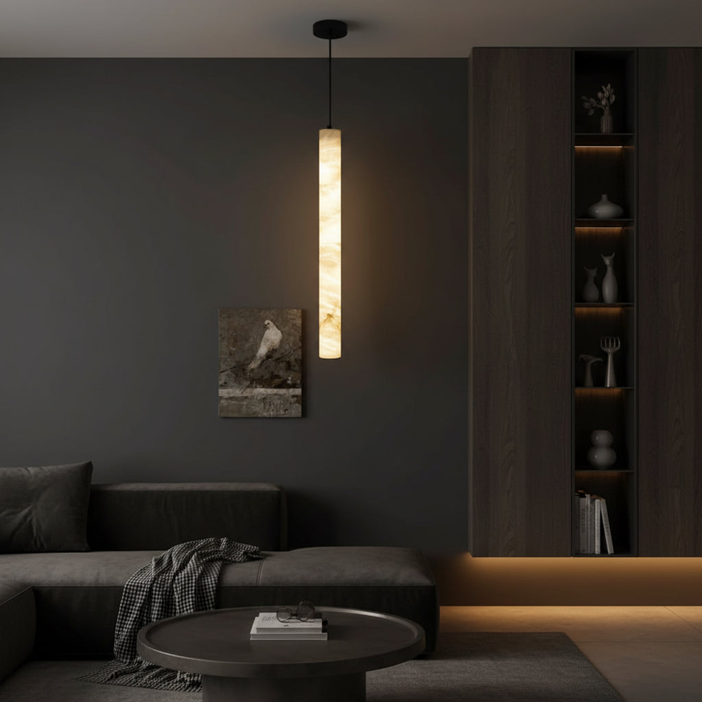 Tubular alabaster pendant light with black mounting cap and warm light.