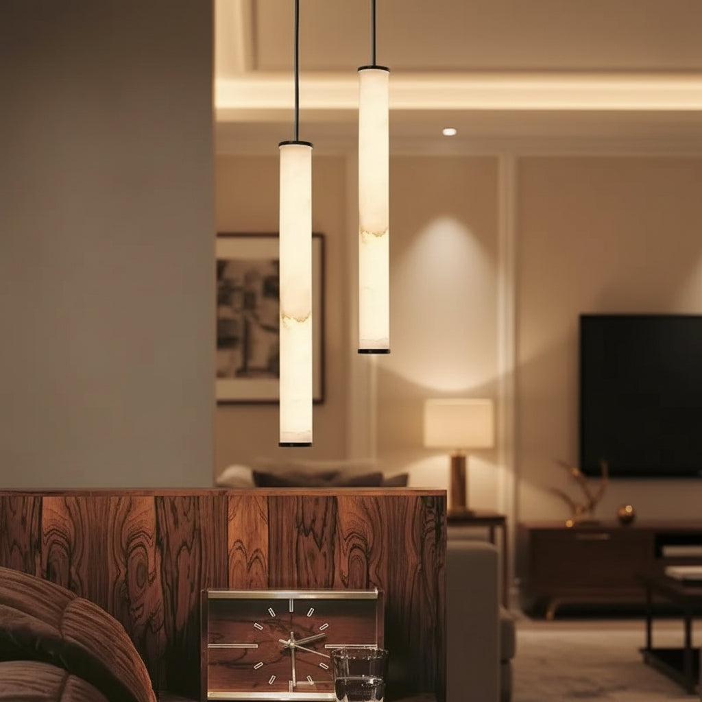 Pair of slim tubular pendant lights with cream alabaster shades and black cords.