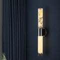 Modern cylindrical wall sconce with glowing alabaster diffuser and black wall mount
