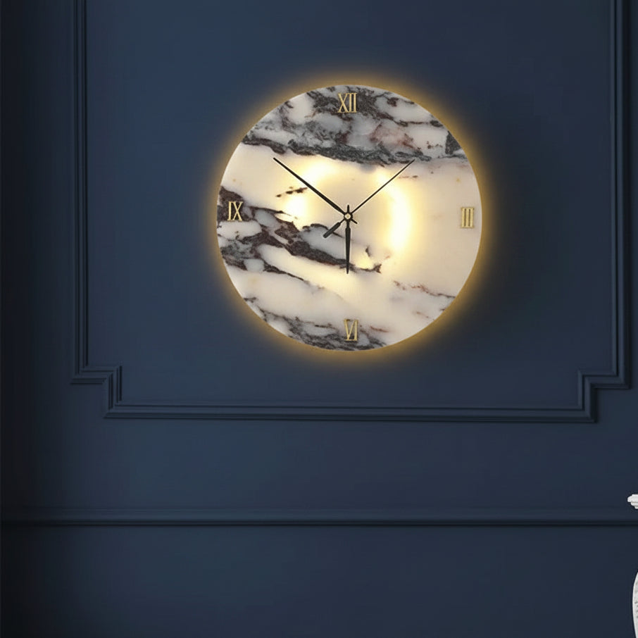 Round marble-pattern backlit wall clock light with Roman numerals on a dark wall