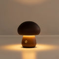 Dark wood mushroom table lamp glowing softly with round power button