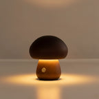 Dark wood mushroom table lamp glowing softly with round power button