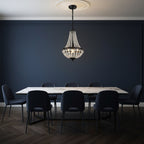 Dark metal crystal basket chandelier with beaded shade centered above dining table