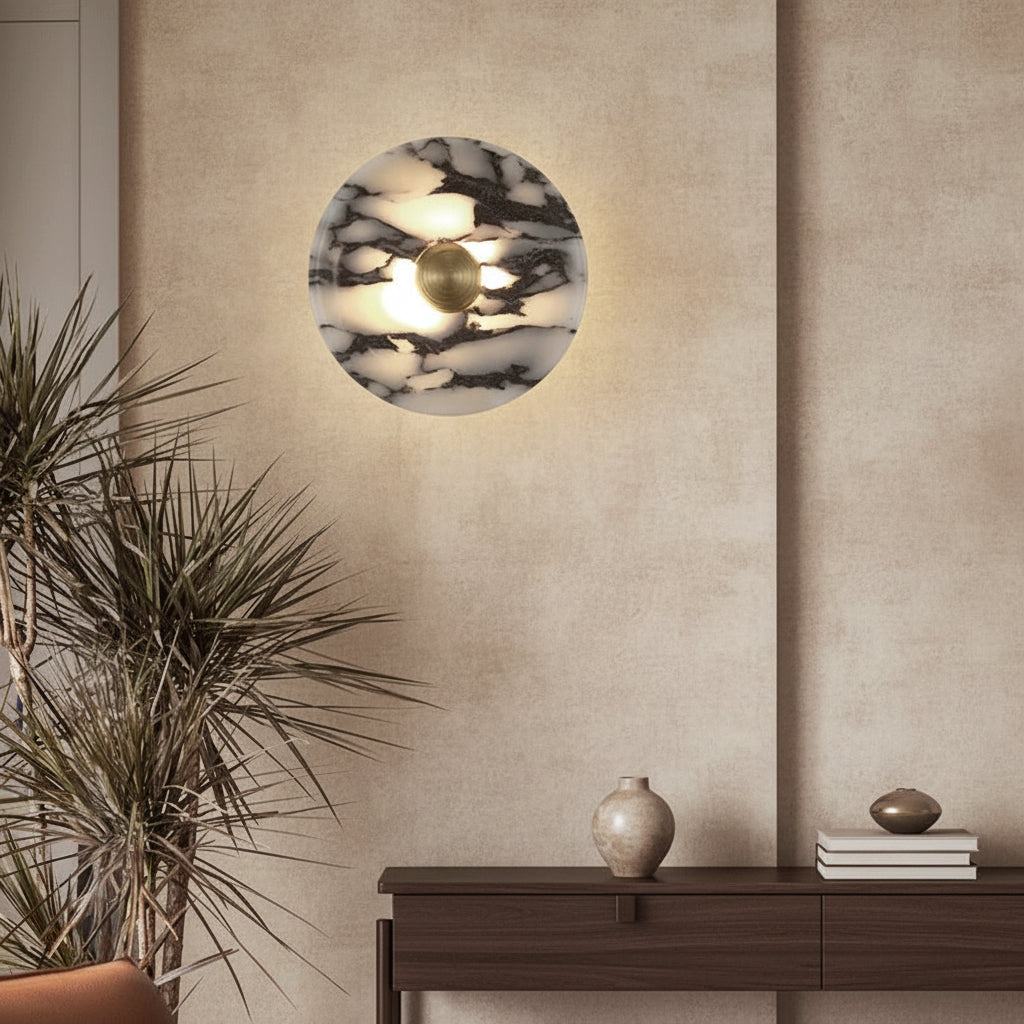 Round marble wall sconce with warm backlit center and gold circular diffuser