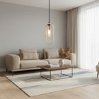 Oval travertine pendant light with clear bulb glow and black cord, hanging indoors