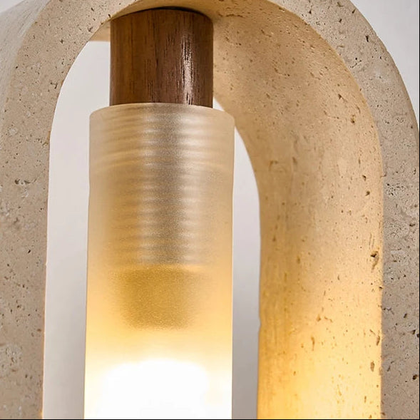 Close-up of oval travertine pendant light showing warm bulb glow and textured stone