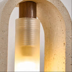Close-up of oval travertine pendant light showing warm bulb glow and textured stone