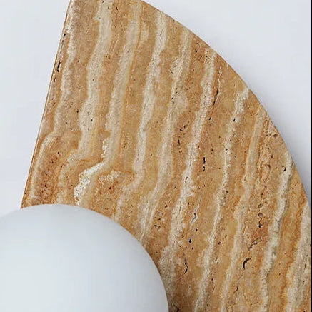 Travertine half-moon wall sconce close-up with round white globe diffuser