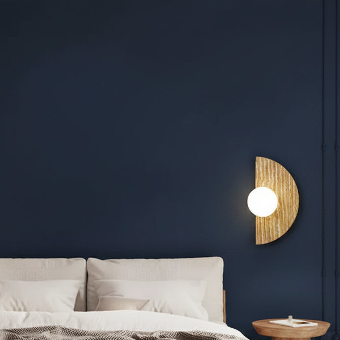 Half-moon travertine wall sconce with lit round white diffuser on wall