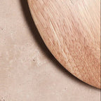 Round travertine wall light with circular halo and warm glow, close-up outer disk
