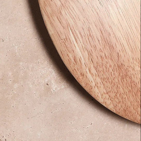 Round travertine wall light with circular halo and warm glow, close-up outer disk