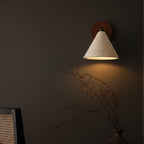 Wall sconce with conical speckled shade, black bar, round wood mount, warm glow