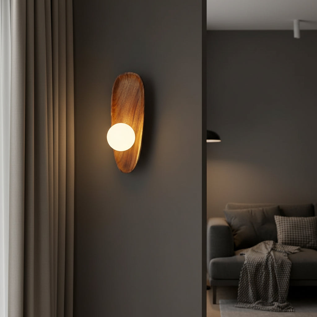 Oval wood backplate wall sconce with glowing bulb mounted on wall