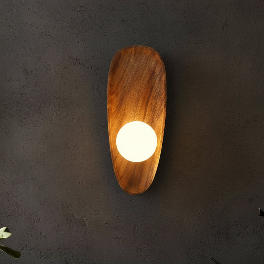 Wood oval backplate wall sconce with round lit bulb, warm glow