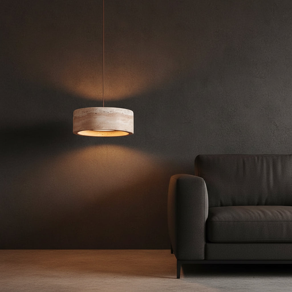 Round travertine drum pendant light glowing in a dim room