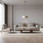 Round travertine drum pendant light hanging over a sofa
