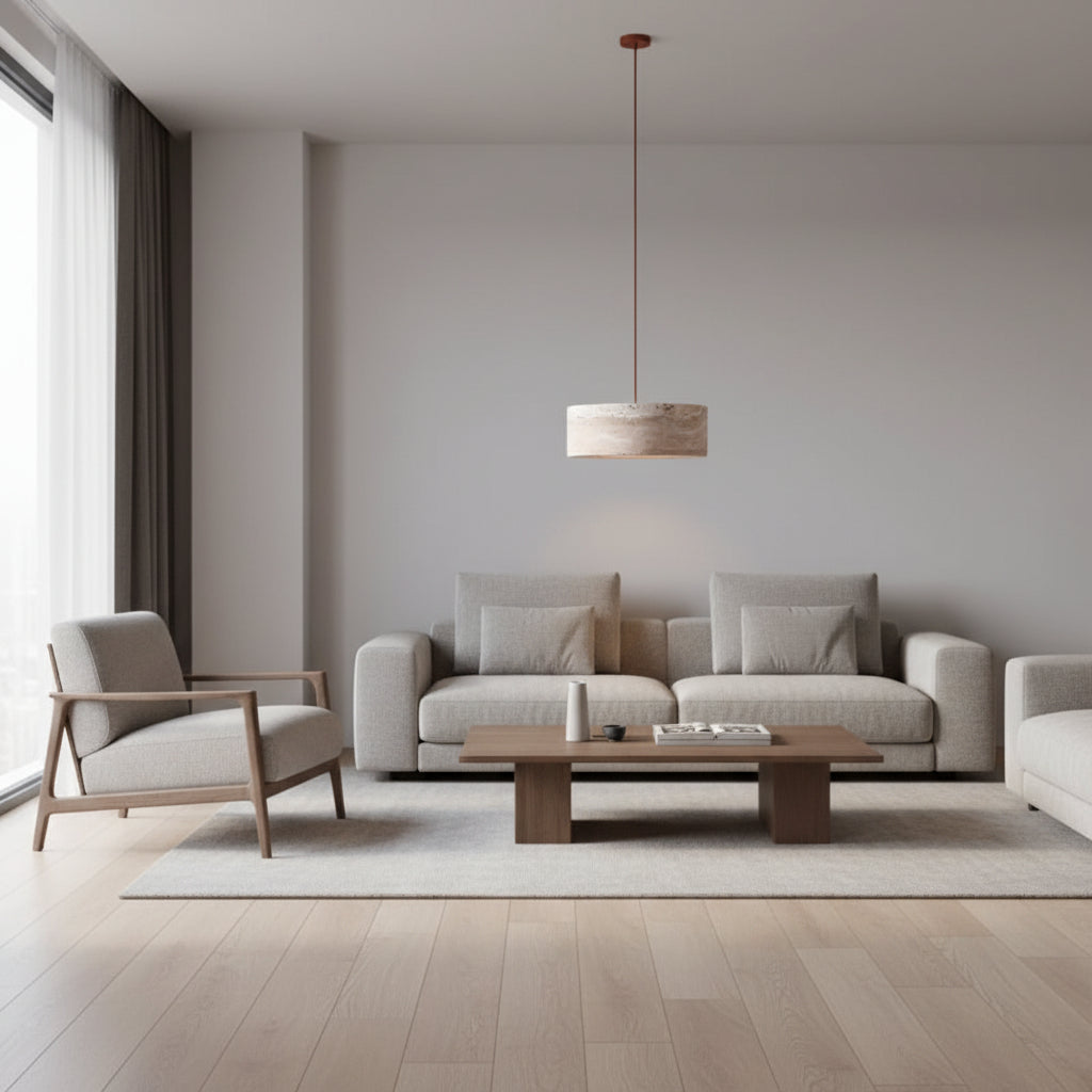 Round travertine drum pendant light hanging over a sofa