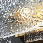 Close-up of rectangular ripple glass wall sconce with gold and silver textured glass panel