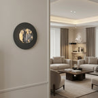 Round black wall sconce with backlit marble disk on interior wall