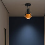 Black spotlight ceiling light with orange cup shade on a flush ceiling mount