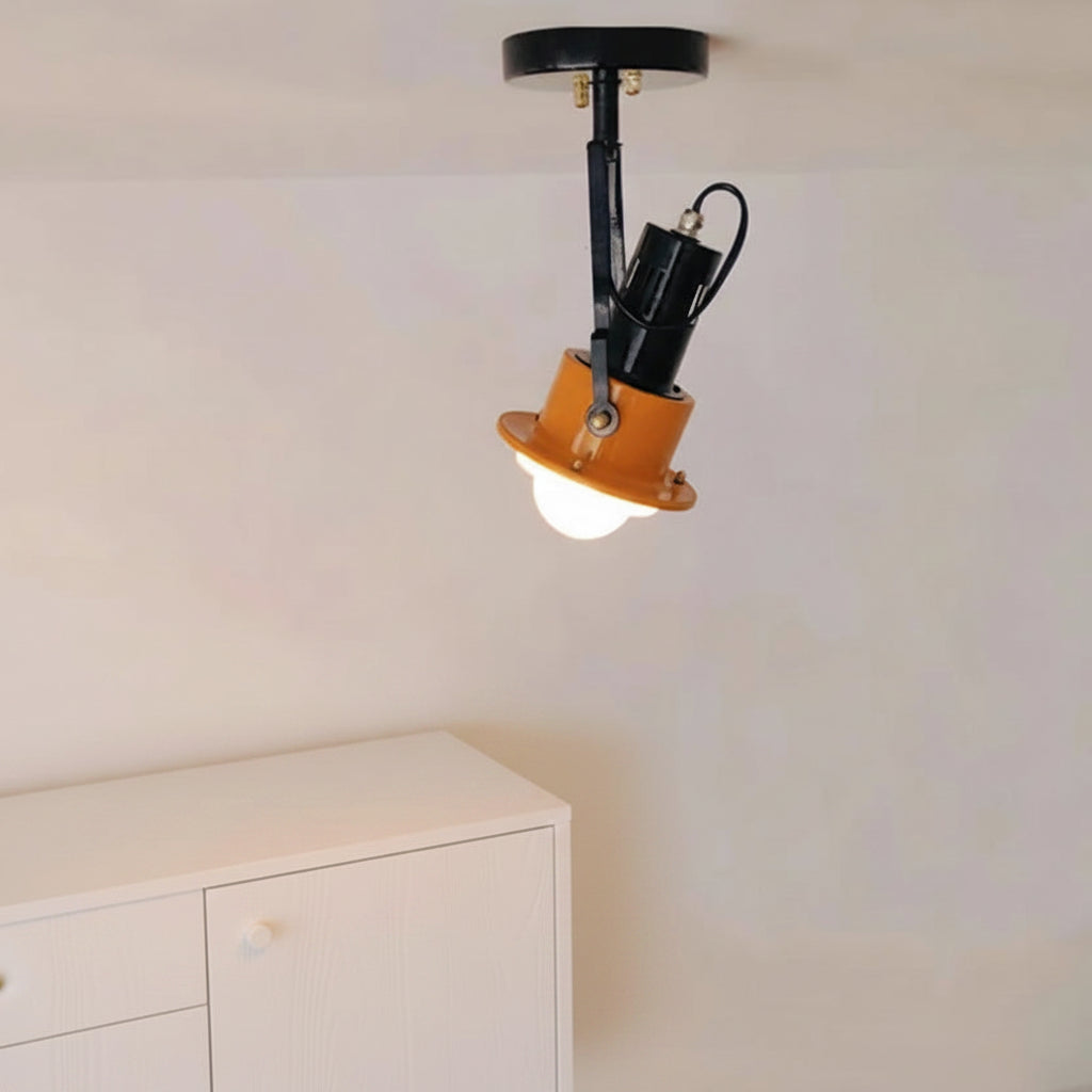 Adjustable black spotlight ceiling light with orange shade on a flush mount