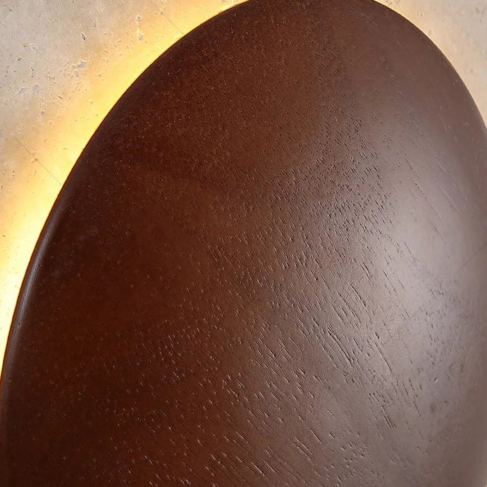 Textured circular diffuser of square wall sconce, warm backlit glow around ring