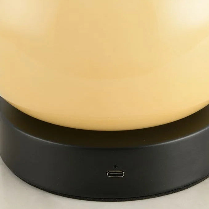 Black lamp base with USB port beneath the glowing gourd shade.
