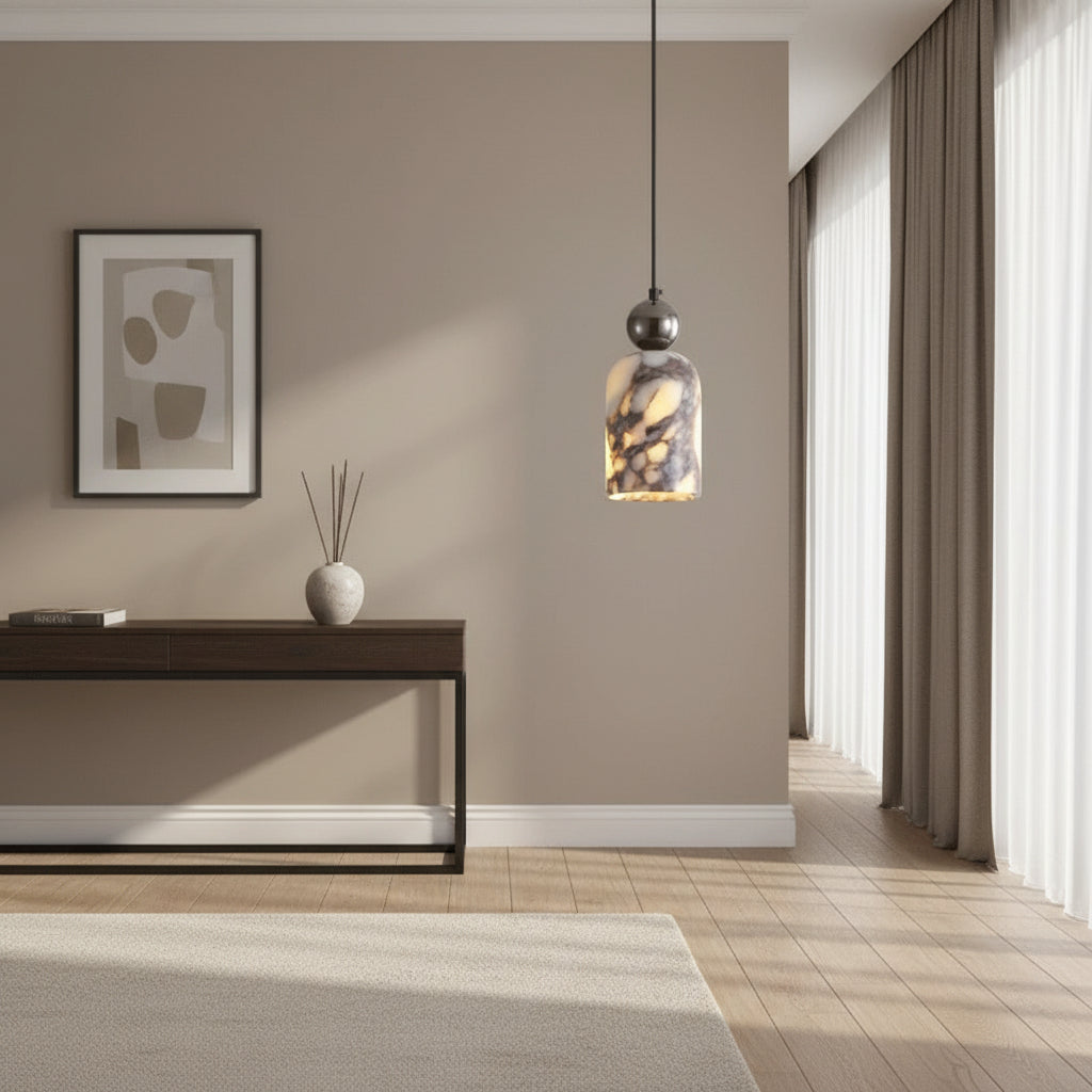 Single marbled glass pendant light with dark metal top, hanging above room seating.