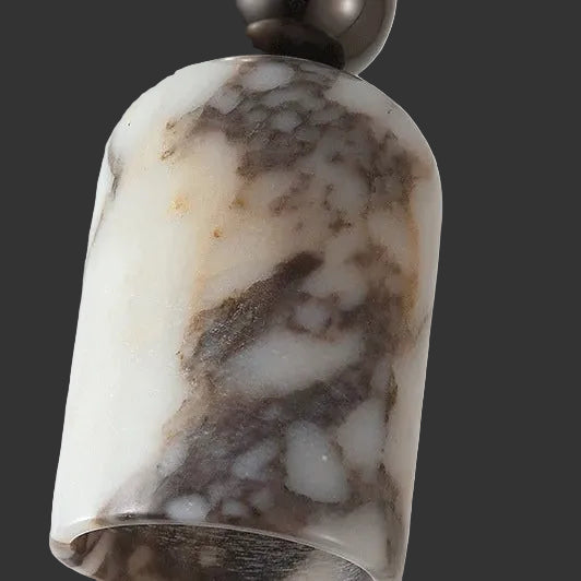 Marbled glass pendant shade close-up with warm yellow highlights and dark speckled base.