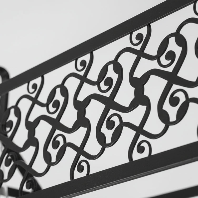 Black metal scrollwork cage panel detail on a long ceiling light fixture