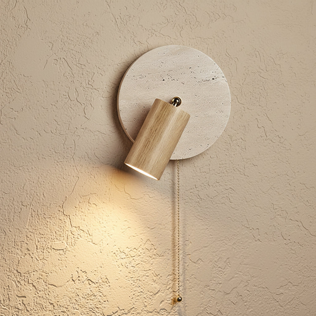 Spotlight wall sconce close-up: round travertine disc, light wood cylinder shade, pull cord