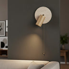 Wall spotlight sconce with round travertine disc, light wood cylinder shade, pull cord