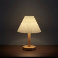 Pleated conical table lamp with cream shade and light wood round base