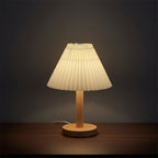 Pleated conical table lamp with cream shade and light wood round base