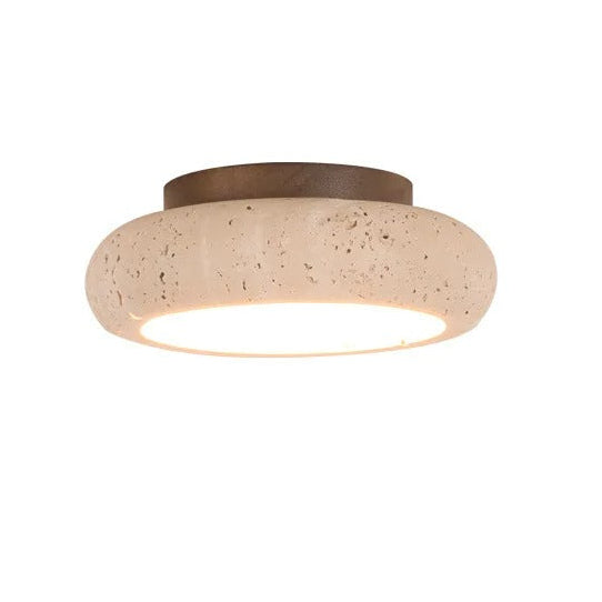 Round travertine flush mount ceiling light with speckled stone shade and warm bulb light