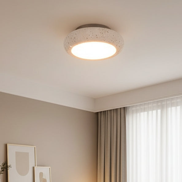 Round flush mount ceiling light with textured speckled stone shade and warm glow