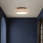 Round flush mount ceiling light with speckled travertine shade and warm light glow