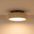 Round travertine ceiling flush mount light with speckled stone shade and warm glow