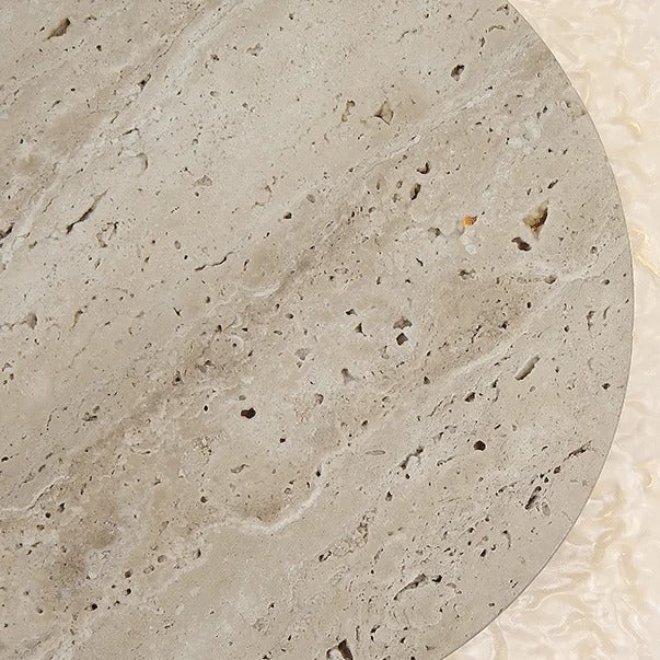 Close-up of travertine disc wall light with speckled beige stone texture